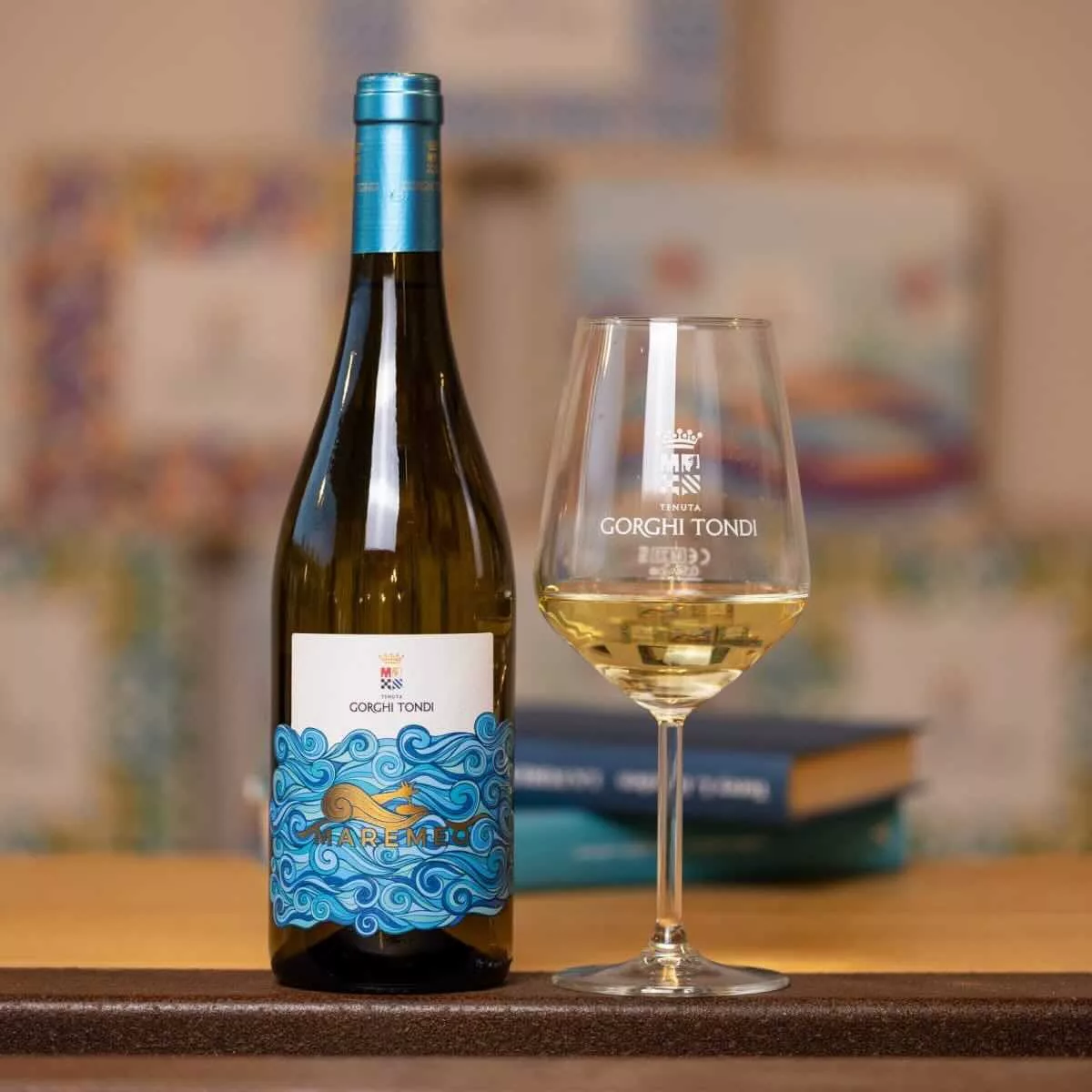 Fles Gorghi Tondi Maremeo witte wijn naast een gevuld wijnglas met het Gorghi Tondi-logo