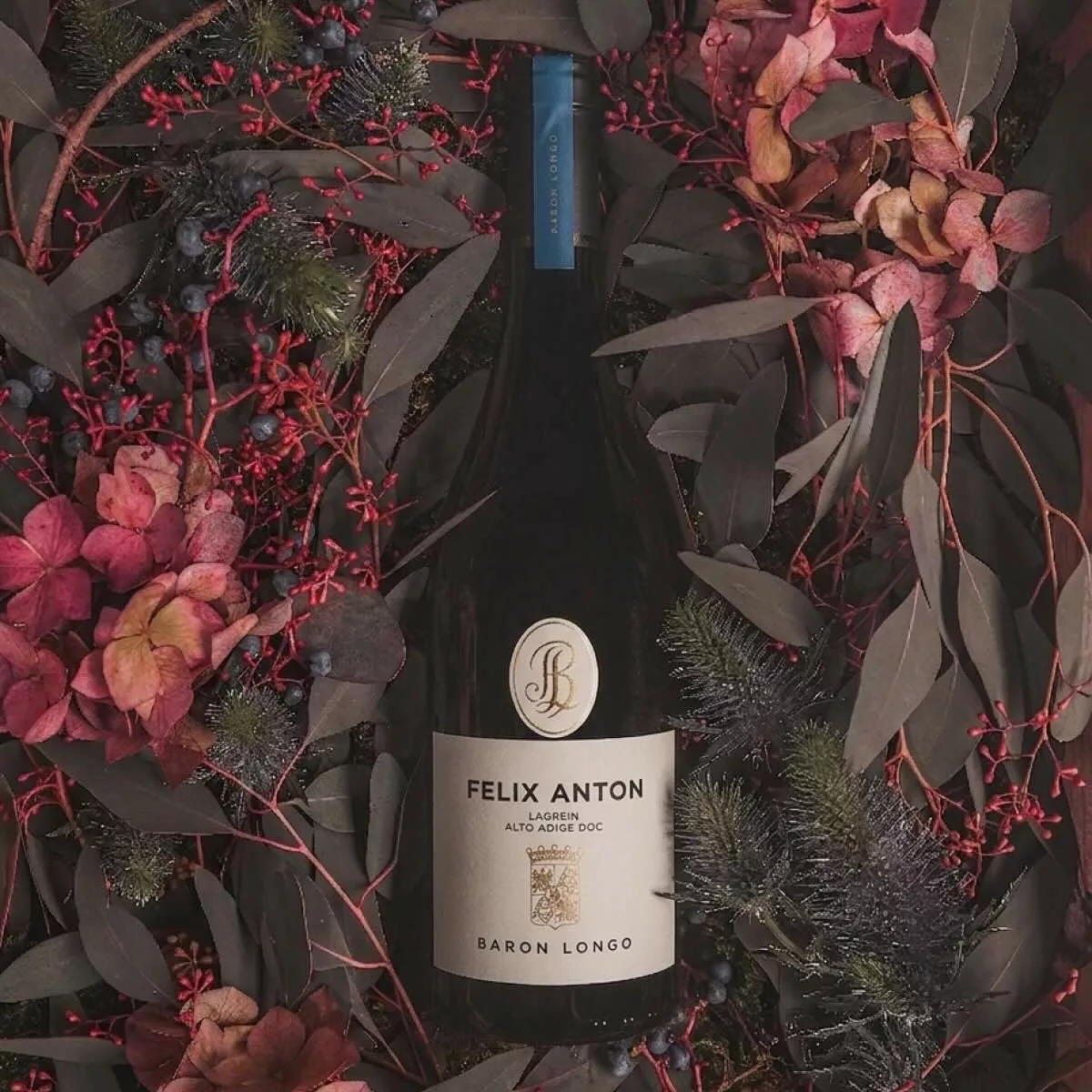 Baron Longo Felix Anton Lagrein fles tussen alpine bloemen en takken in het Trudner Horn Natuurpark, Zuid-Tirol